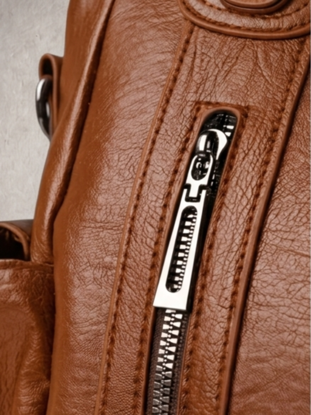 Close-up of the zipper detail on the L'Elyn camel bag