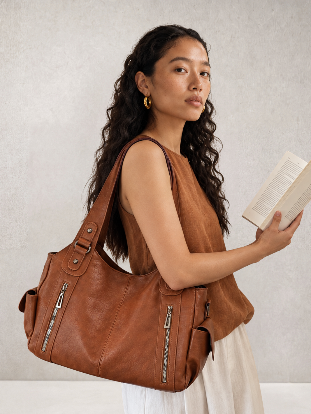 Model wearing the L'Elyn camel vegan leather tote bag on her shoulder