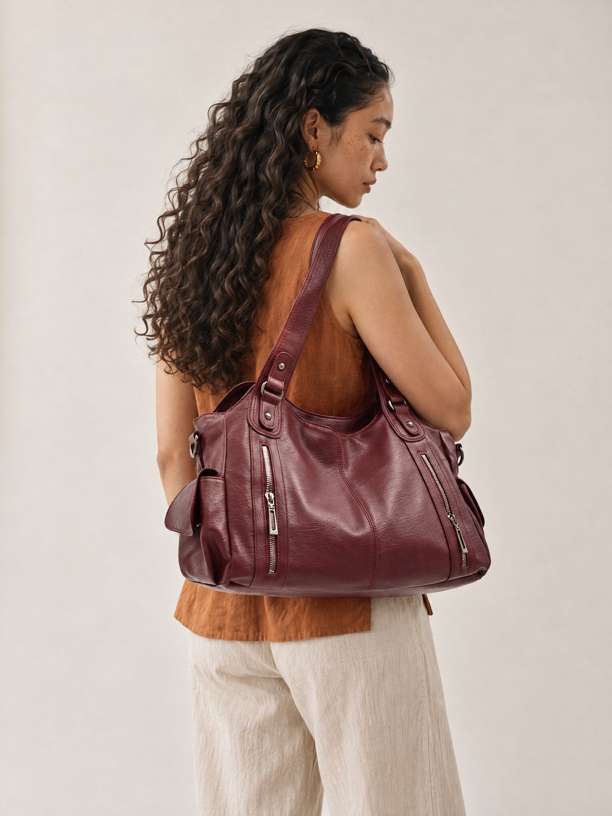 Model wearing the L'Elyn burgundy vegan leather tote bag on her shoulder