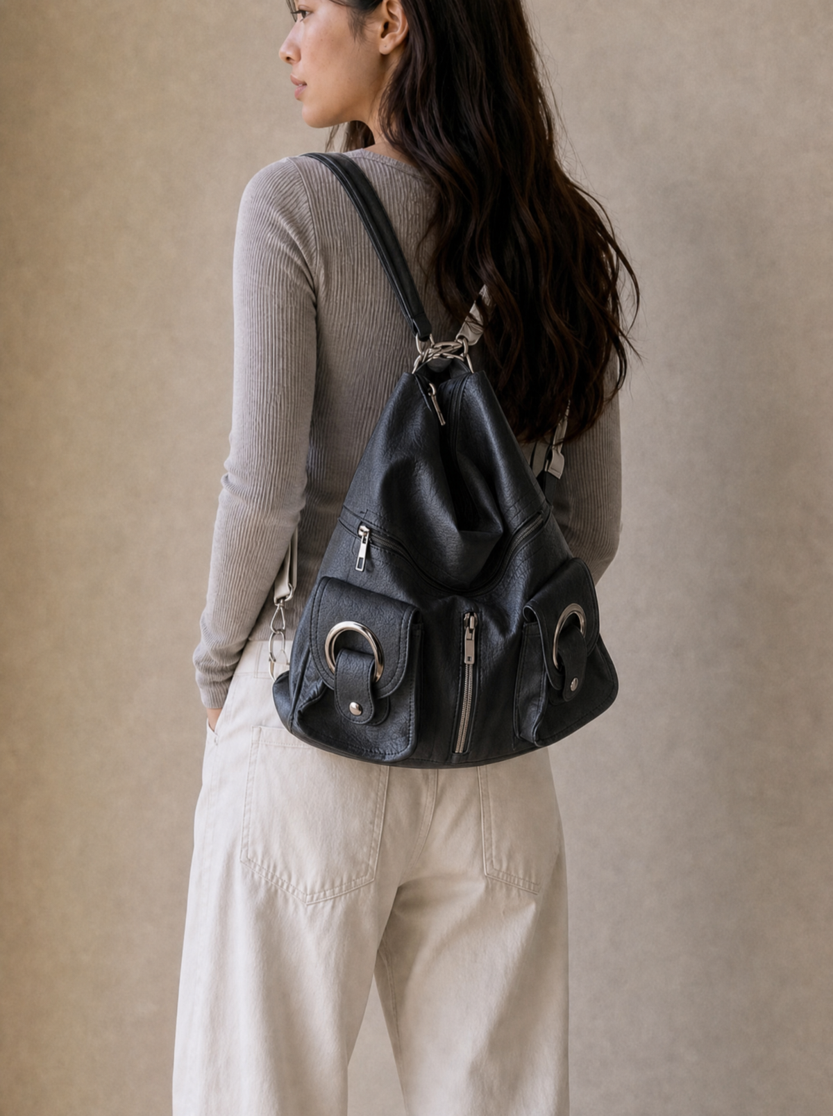Model wearing the Le Mila black bag as a backpack, back view