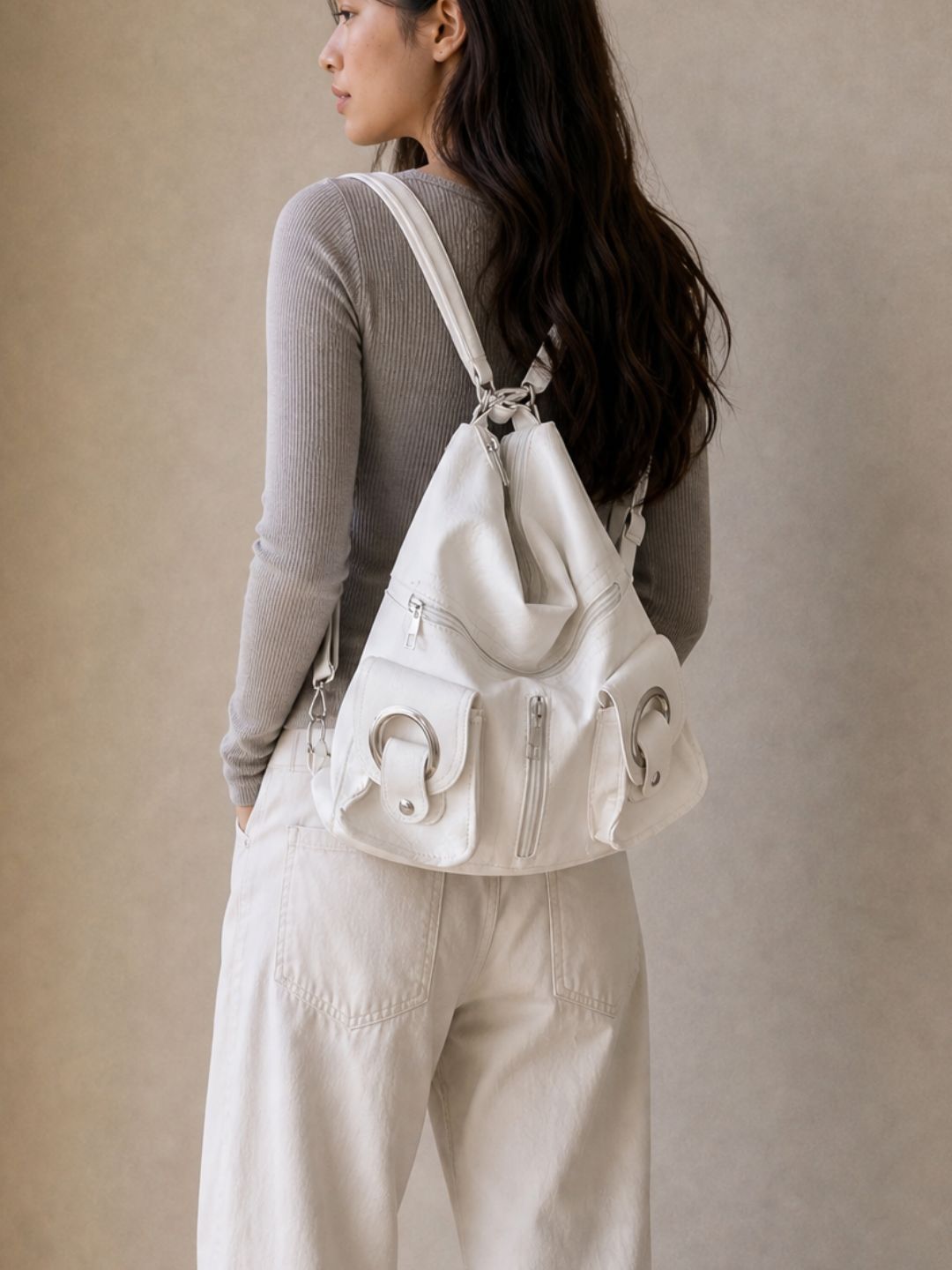 Model wearing the Le Mila white bag as a backpack