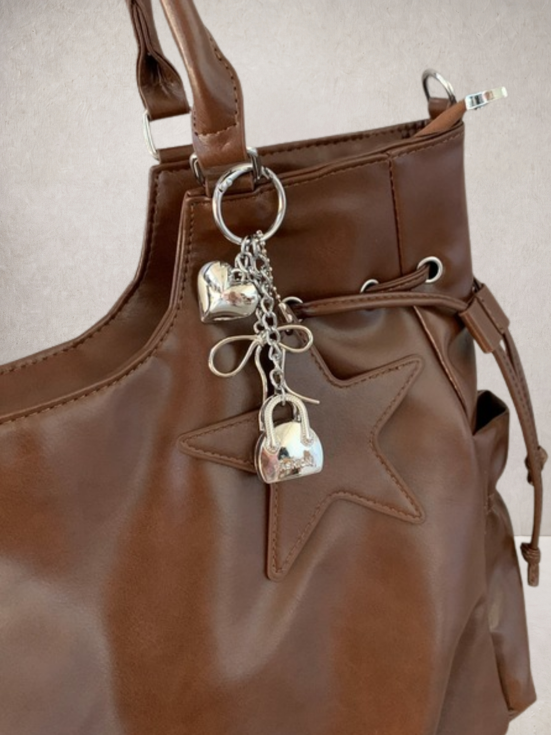 Close-up of the lock and key charm hardware on the Le Nova bag