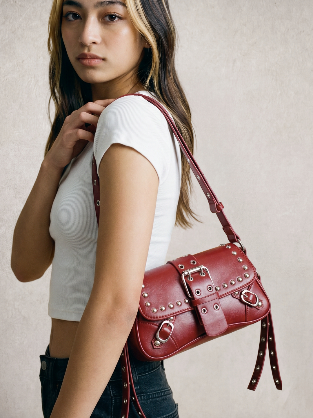Model wearing the Le Robin burgundy studded leather bag on her shoulder