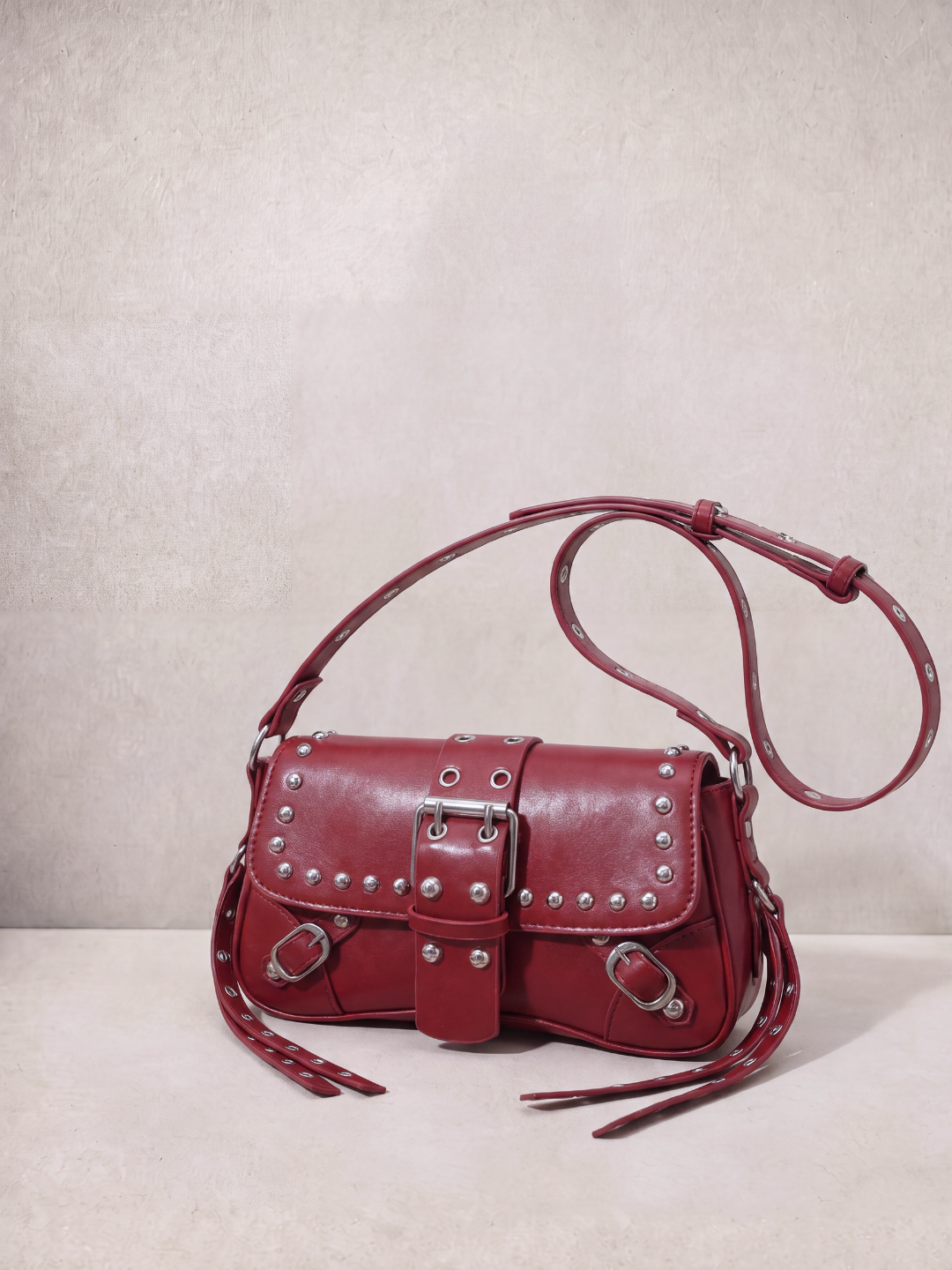 Le Robin bag in burgundy vegan leather with stud details, side view showing the crossbody strap
