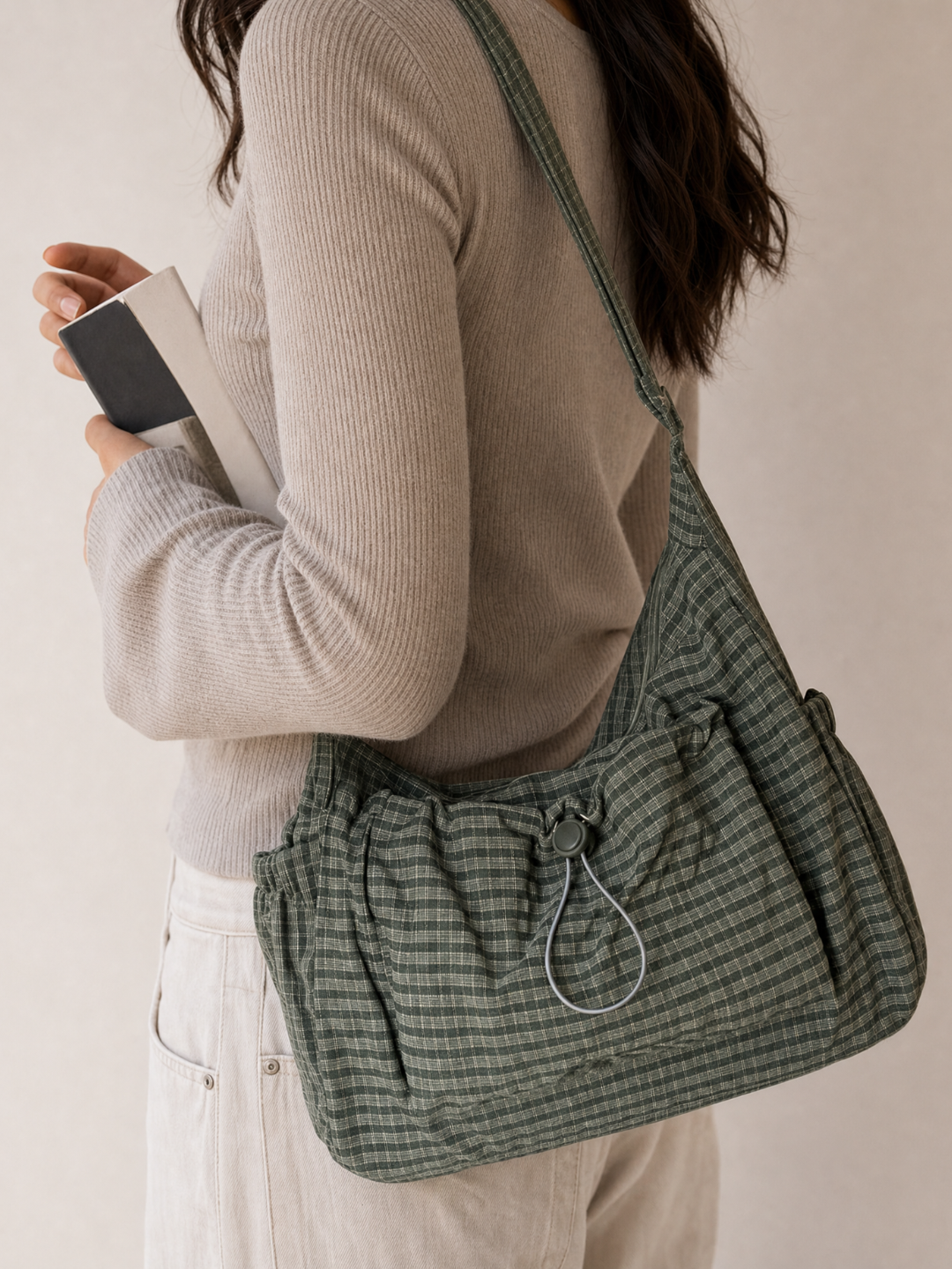 Model wearing the Le Rue green hobo bag while holding her phone
