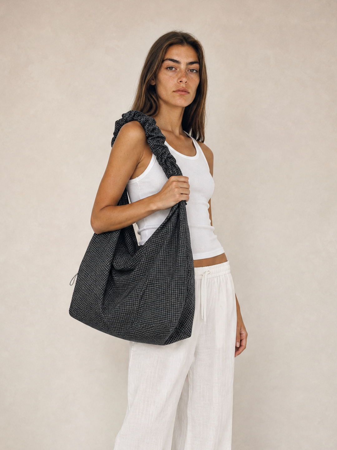 Model wearing the Le Scrunchie black checkered ripstop bag on her shoulder