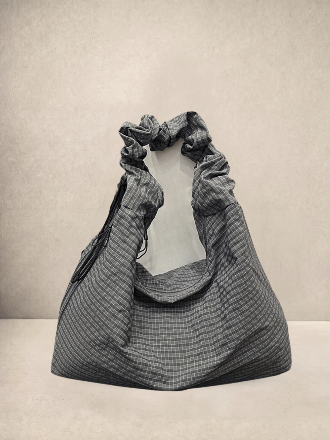 Le Scrunchie hobo bag in grey checkered ripstop fabric, front view