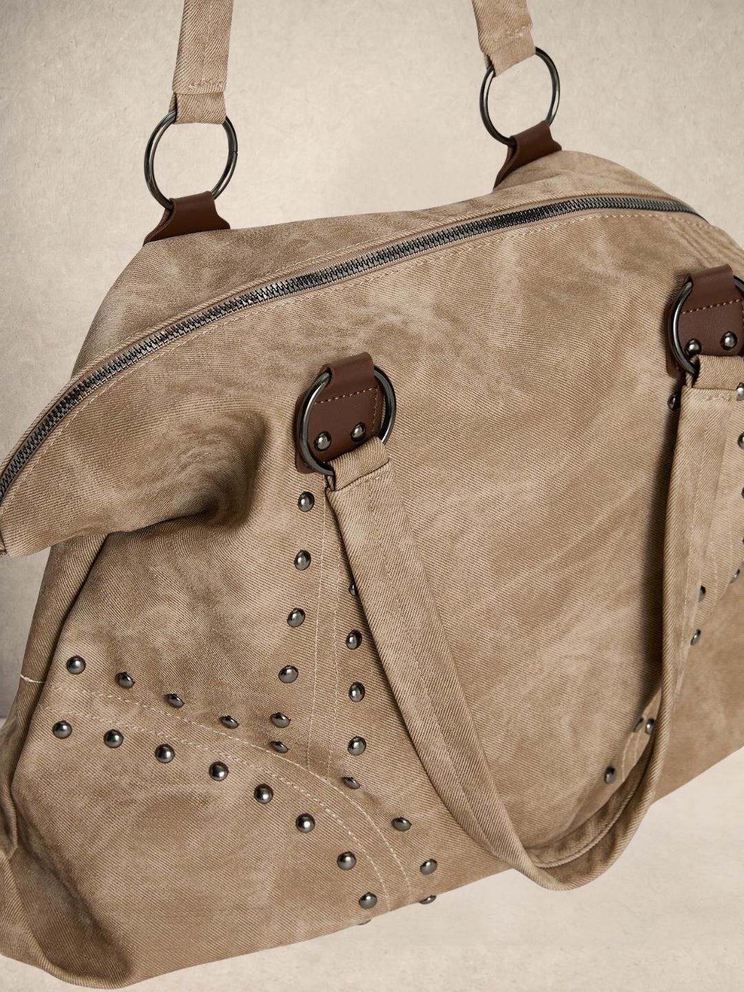 Le Solene shoulder bag in beige vegan leather with stud details, side view