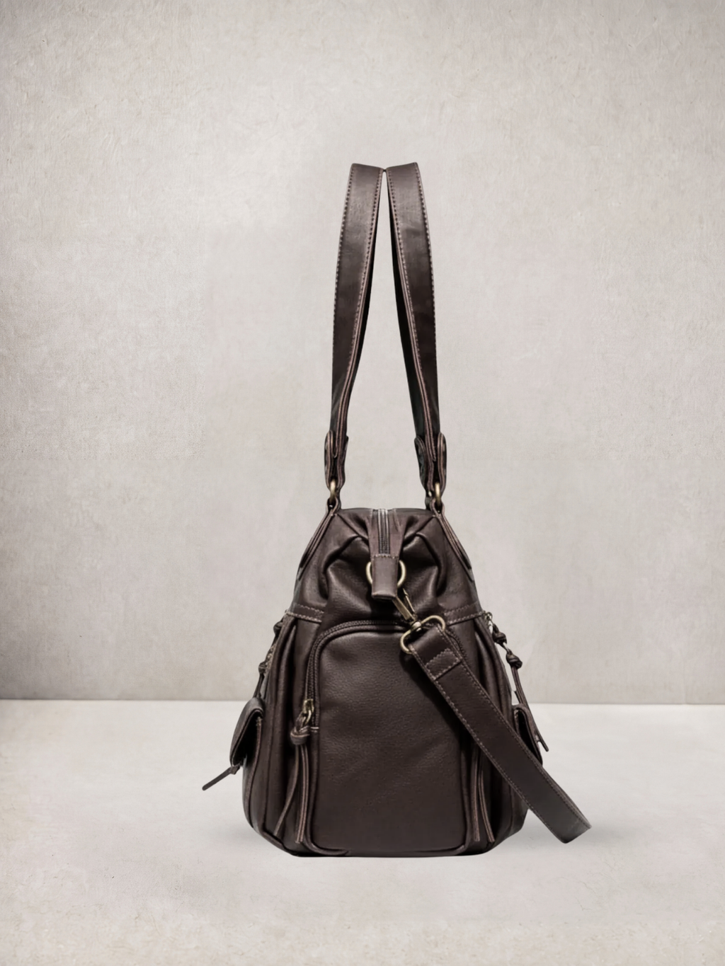 Le Vienne tote bag in dark brown vegan leather, worn as a backpack with straps up