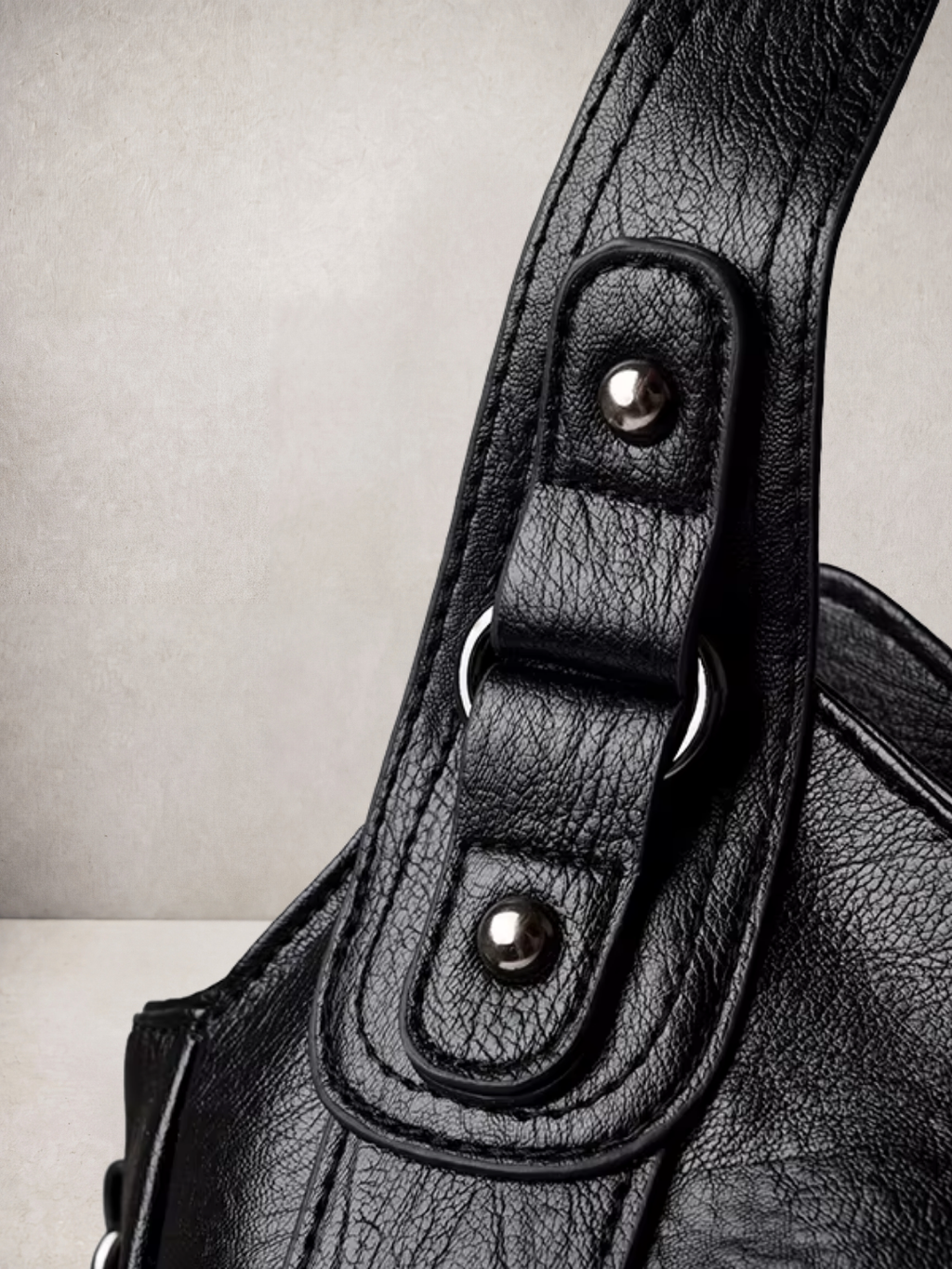 Close-up of the stud and rivet hardware on the L'Elyn bag