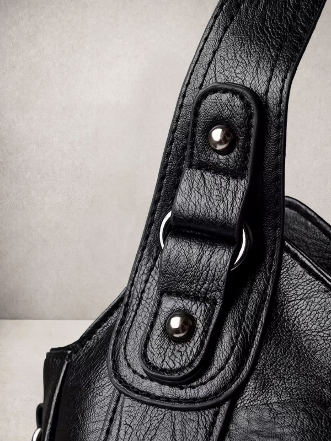 Close-up of the stud and rivet hardware on the L'Elyn bag