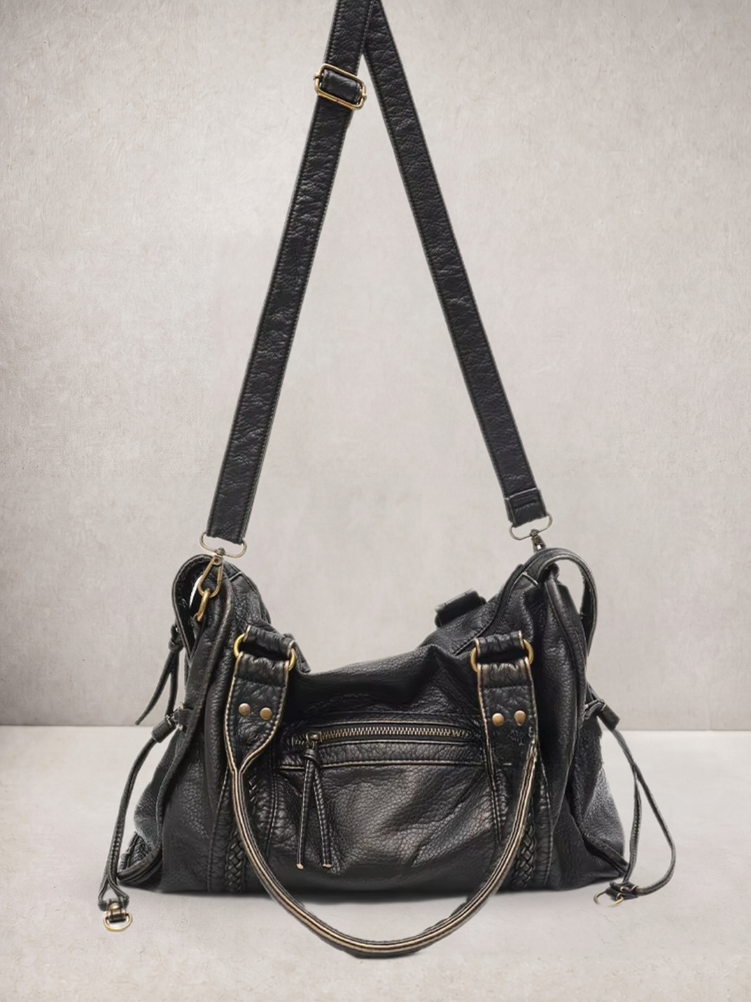 Le Rogue bag in black vegan leather, side view showing the adjustable strap
